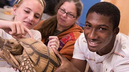 students holding turtle